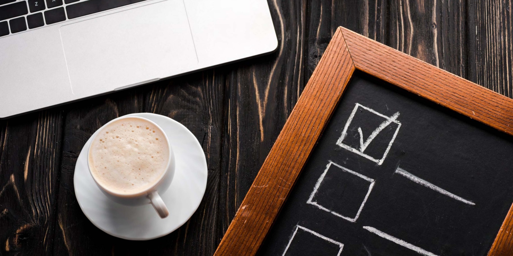 Computer coffee and chalkboard checklist sitting on table-1