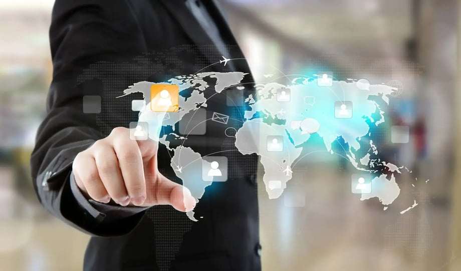 A person in a suit touches a digital screen displaying a world map with icons representing global employee connections and mobility.